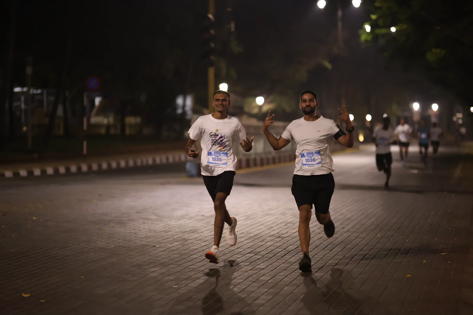 Two Goa Marathon participants running together on the course